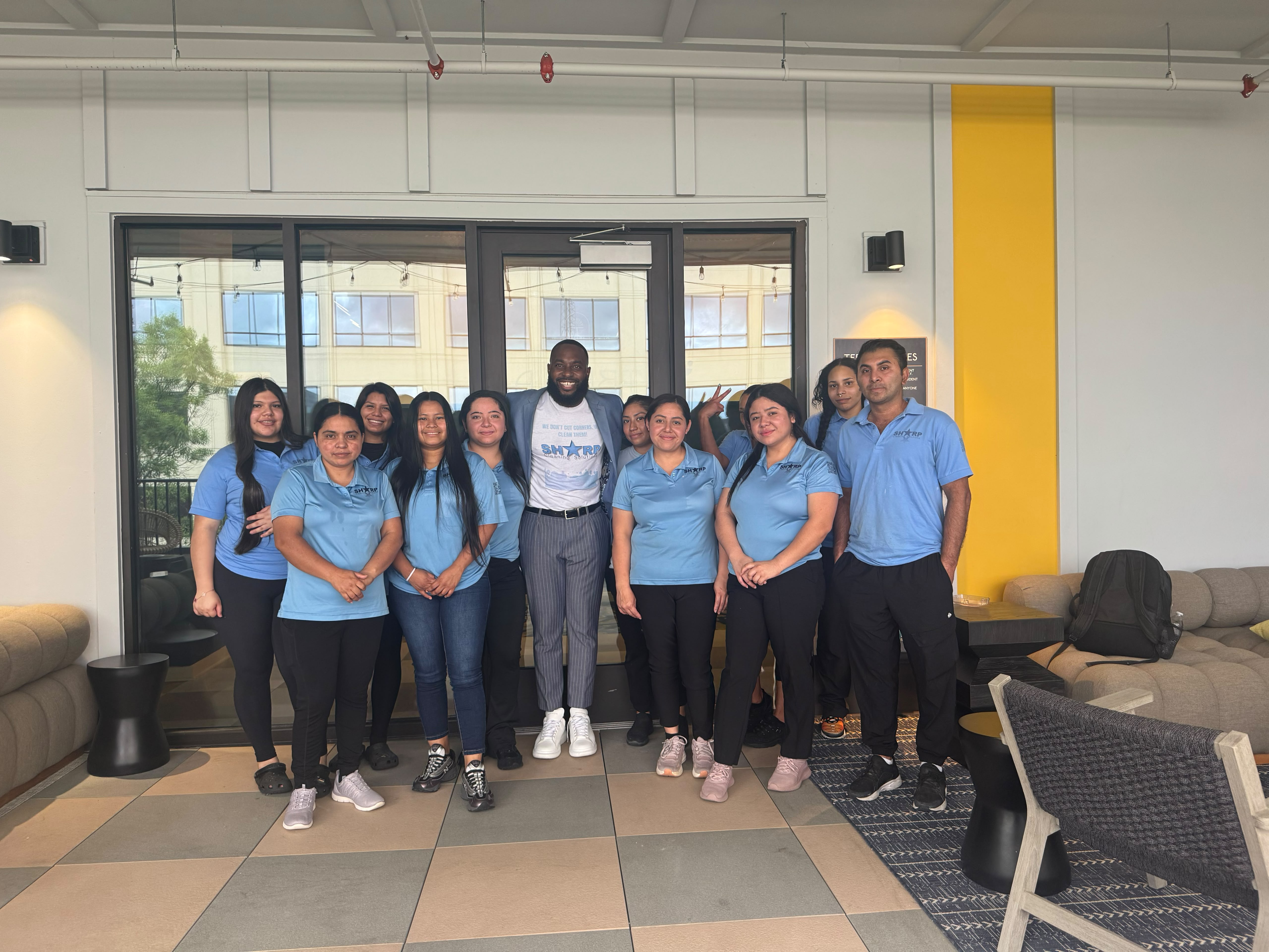 The Sharp Cleaning crew standing together in branded light-blue shirts