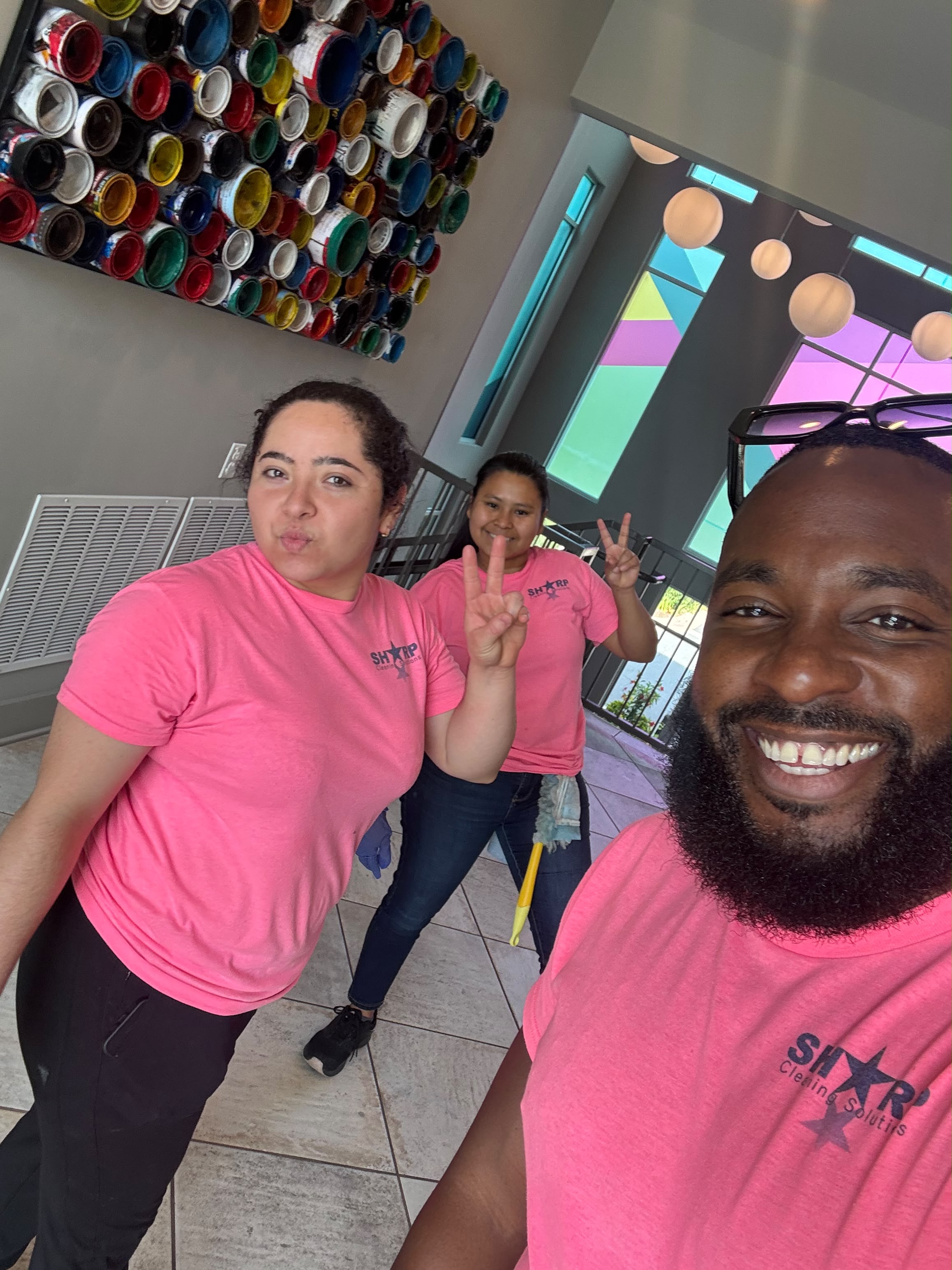 Sharp Cleaning team members on a job in a lobby, in branded pink shirts